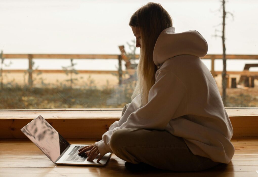 A person working remotely on a laptop by a lake, enjoying a tranquil outdoor environment.