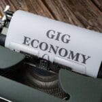 young professionals discussing finances and contracts in a modern office, focusing on gig economy finance strategies for stability in 2026