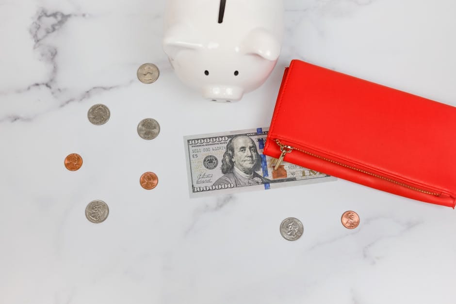woman writing in notebook next to piggy bank and stack of coins, emergency savings guide on desk