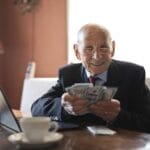 A retirement savings chart and a calculator on a desk, representing smart retirement investing moves for 2026.